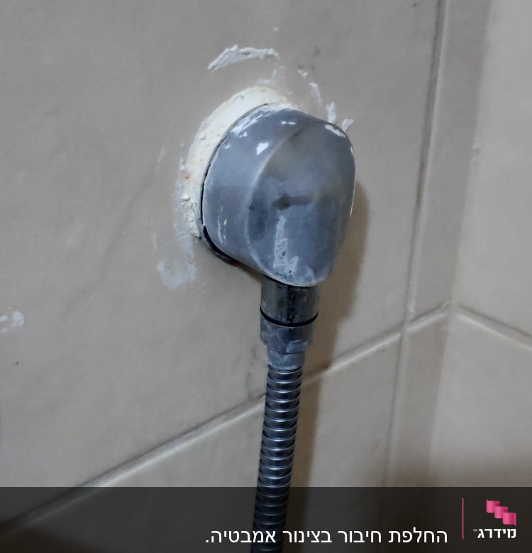 צינור מתכת מחובר לקיר עם חיבור פלסטיק